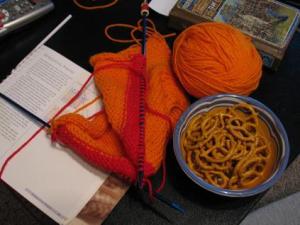 knitting setup, including notebook and mustard pretzels